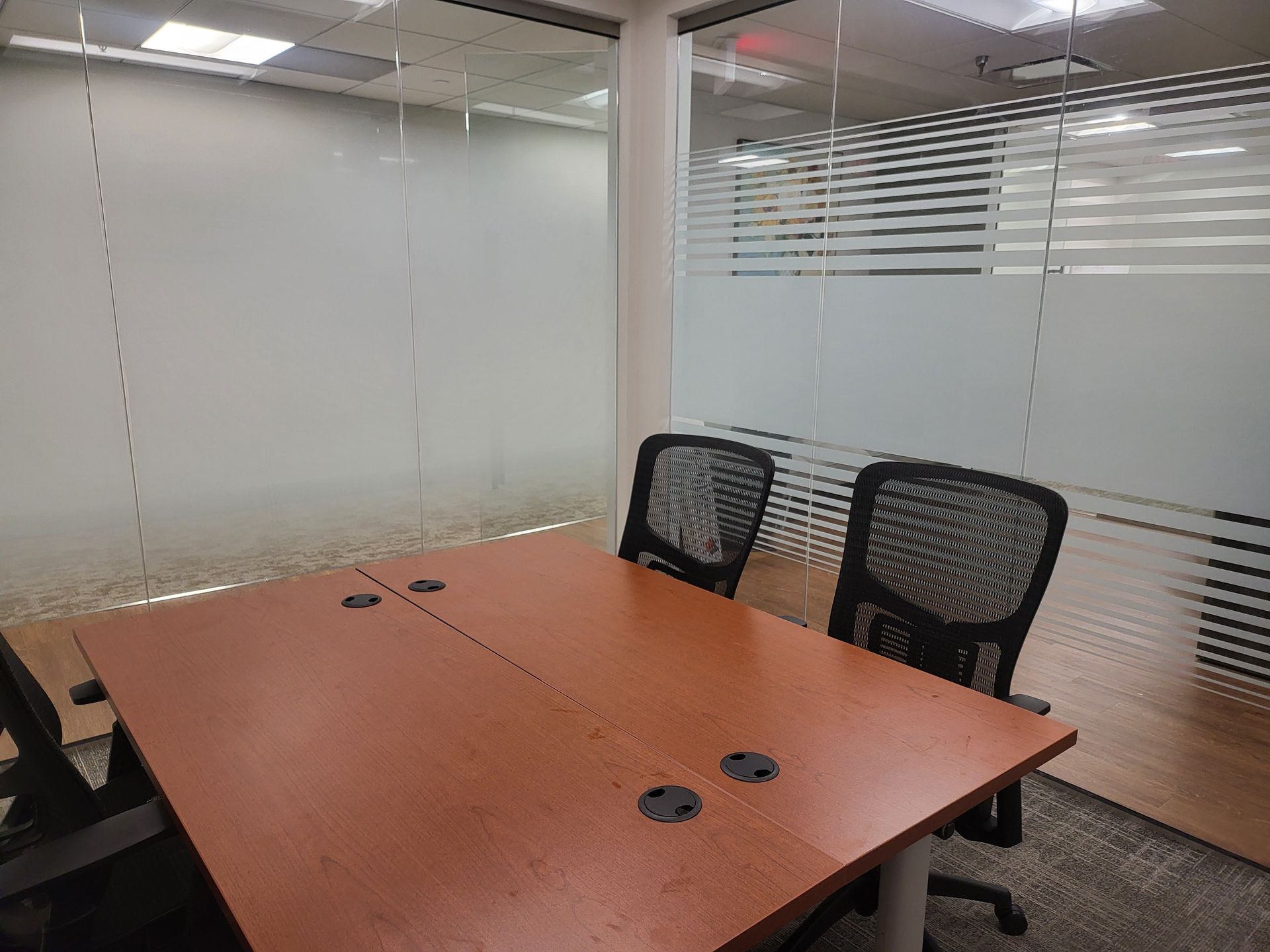 A conference room with a wooden table and two chairs.