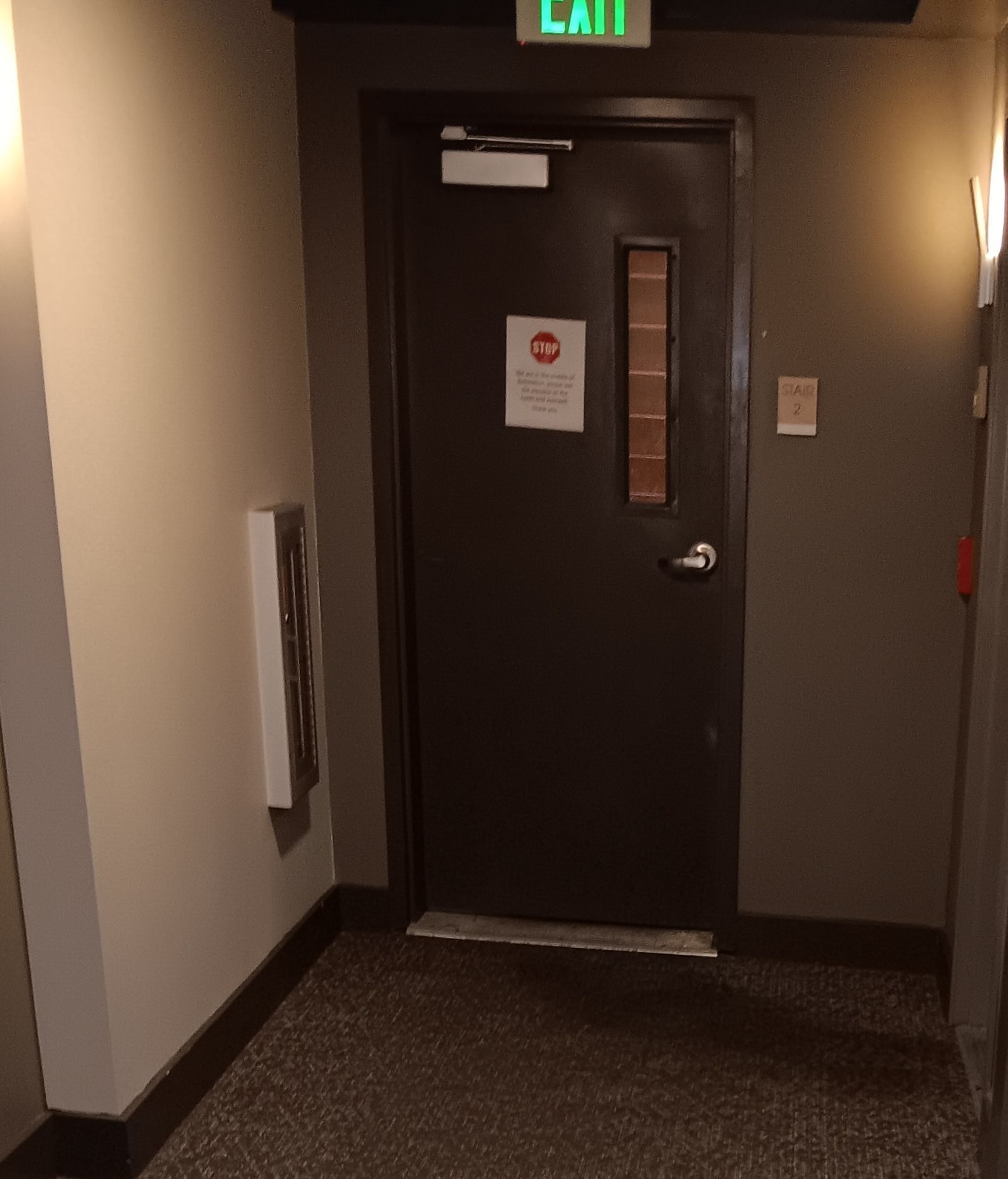 A hallway with an exit sign above the door