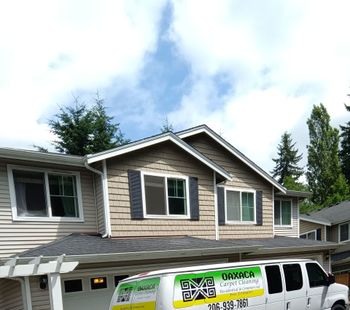 A white van is parked in front of a house
