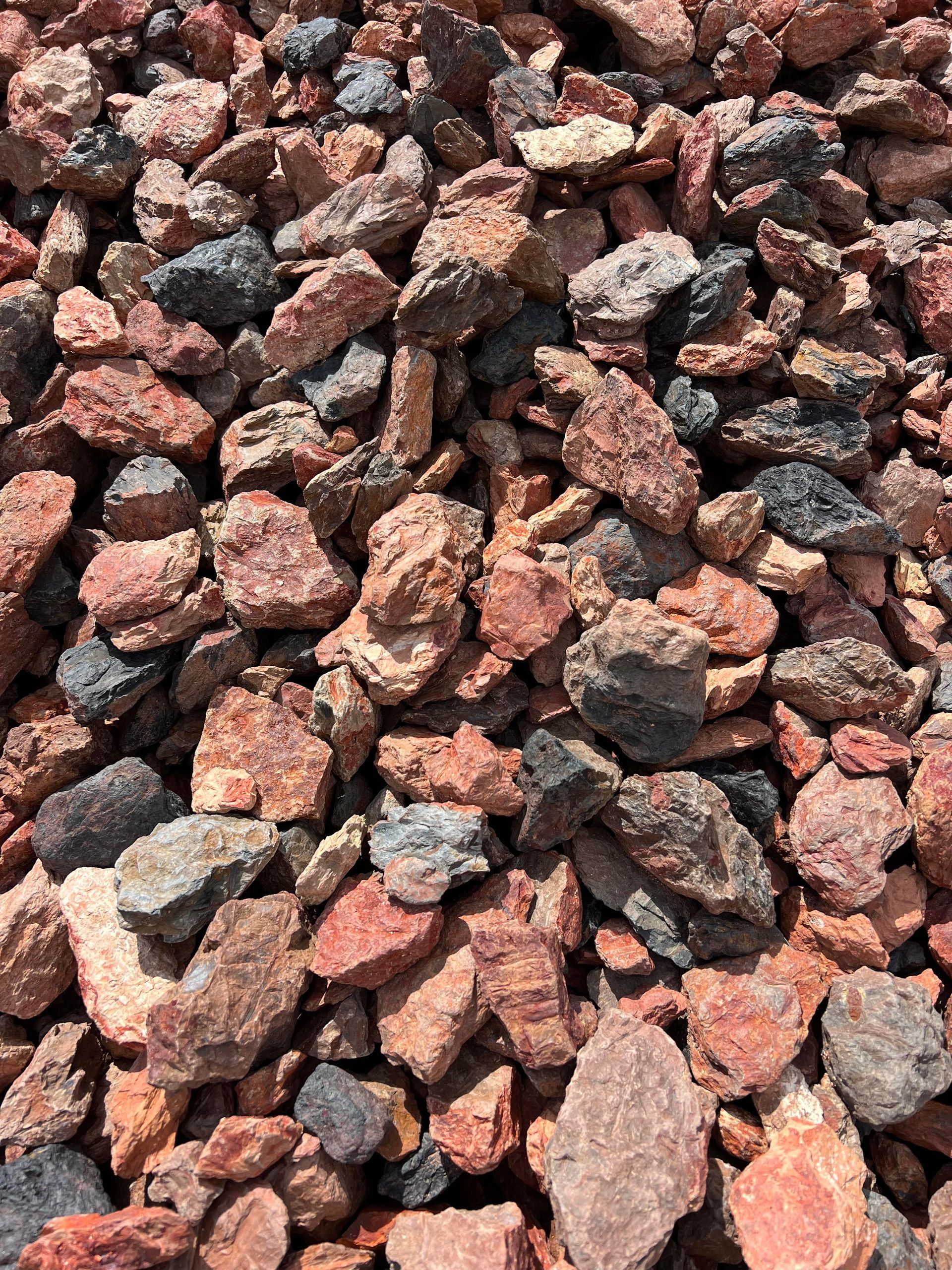 A pile of red and black rocks sitting on top of each other.
