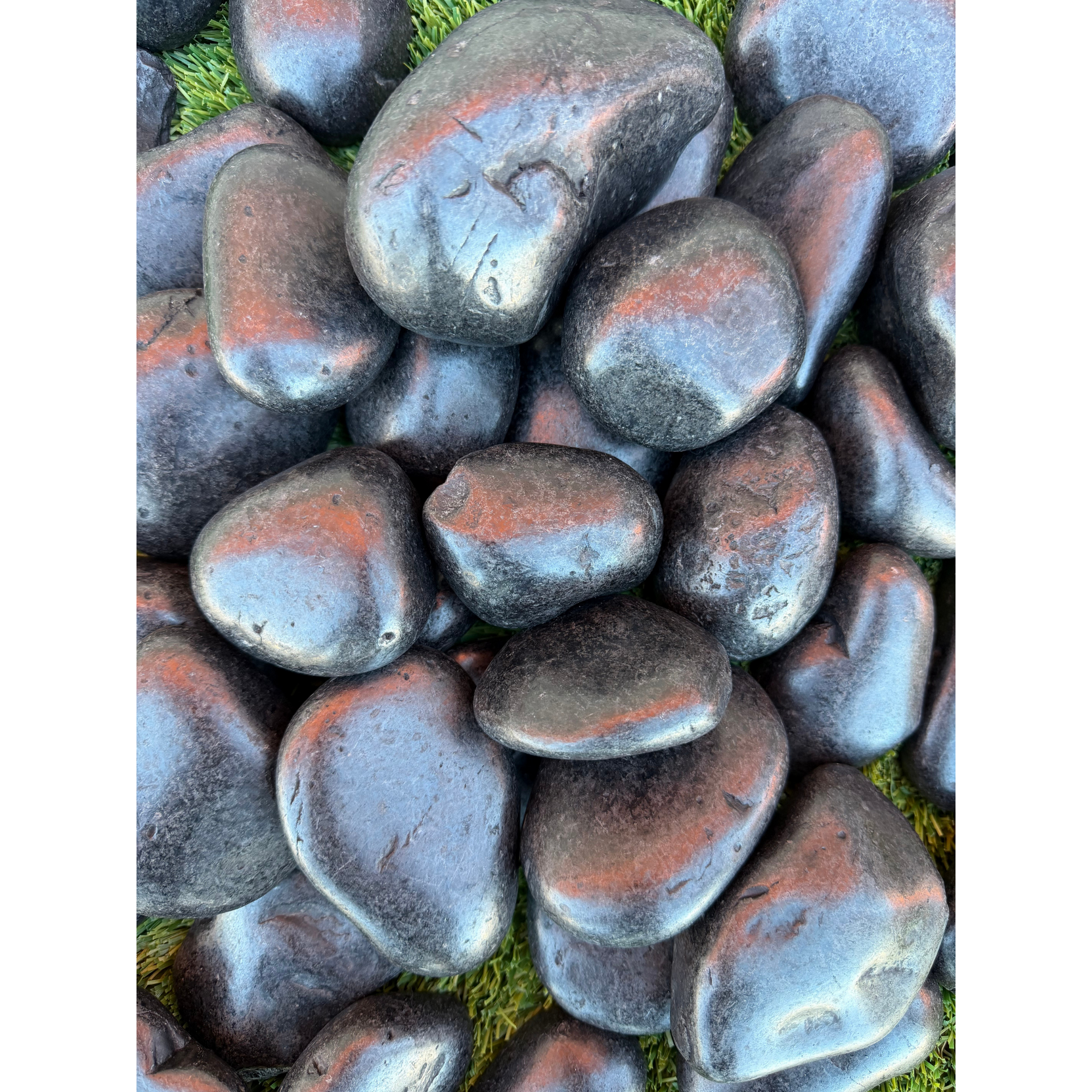 A pile of rocks with a pink rock in the middle.