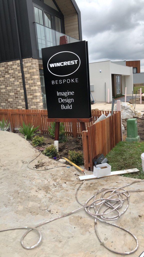 A Sign Is Sitting on The Sidewalk in Front of A Building — Illawarra Sign Group in Bulli, NSW