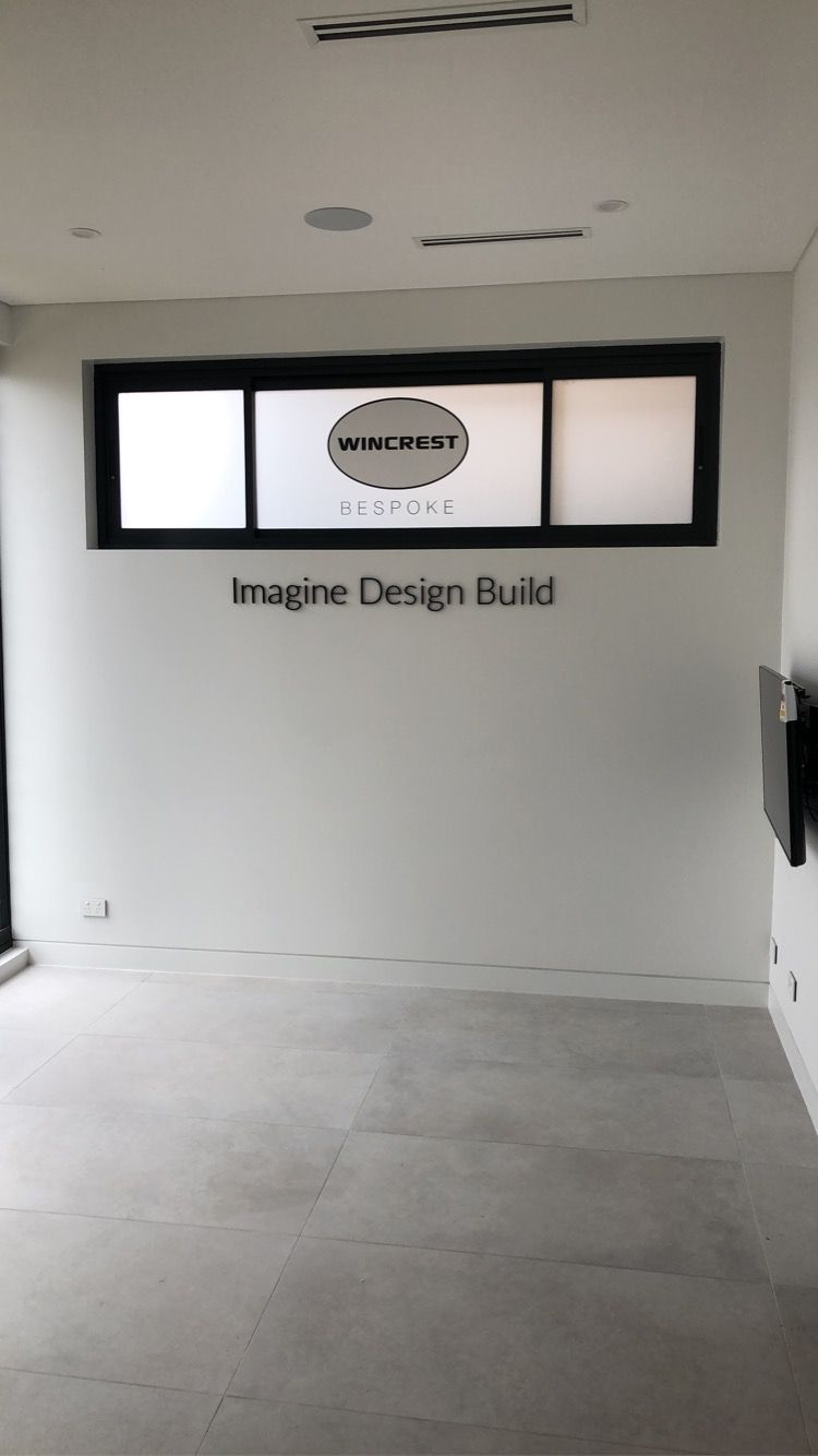 An Empty Room with A Sign on The Wall that Says Imagine Design Build — Illawarra Sign Group in Bulli, NSW