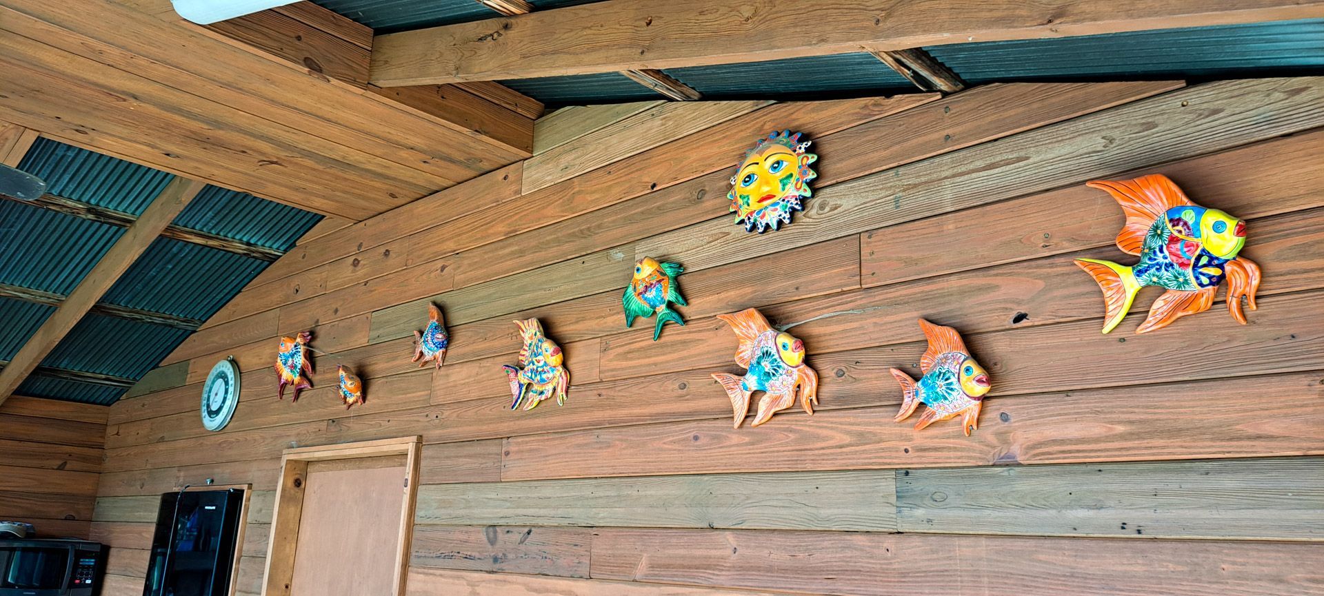 Colorful star-shaped wall decorations on a rustic wooden building exterior with a door and roofline