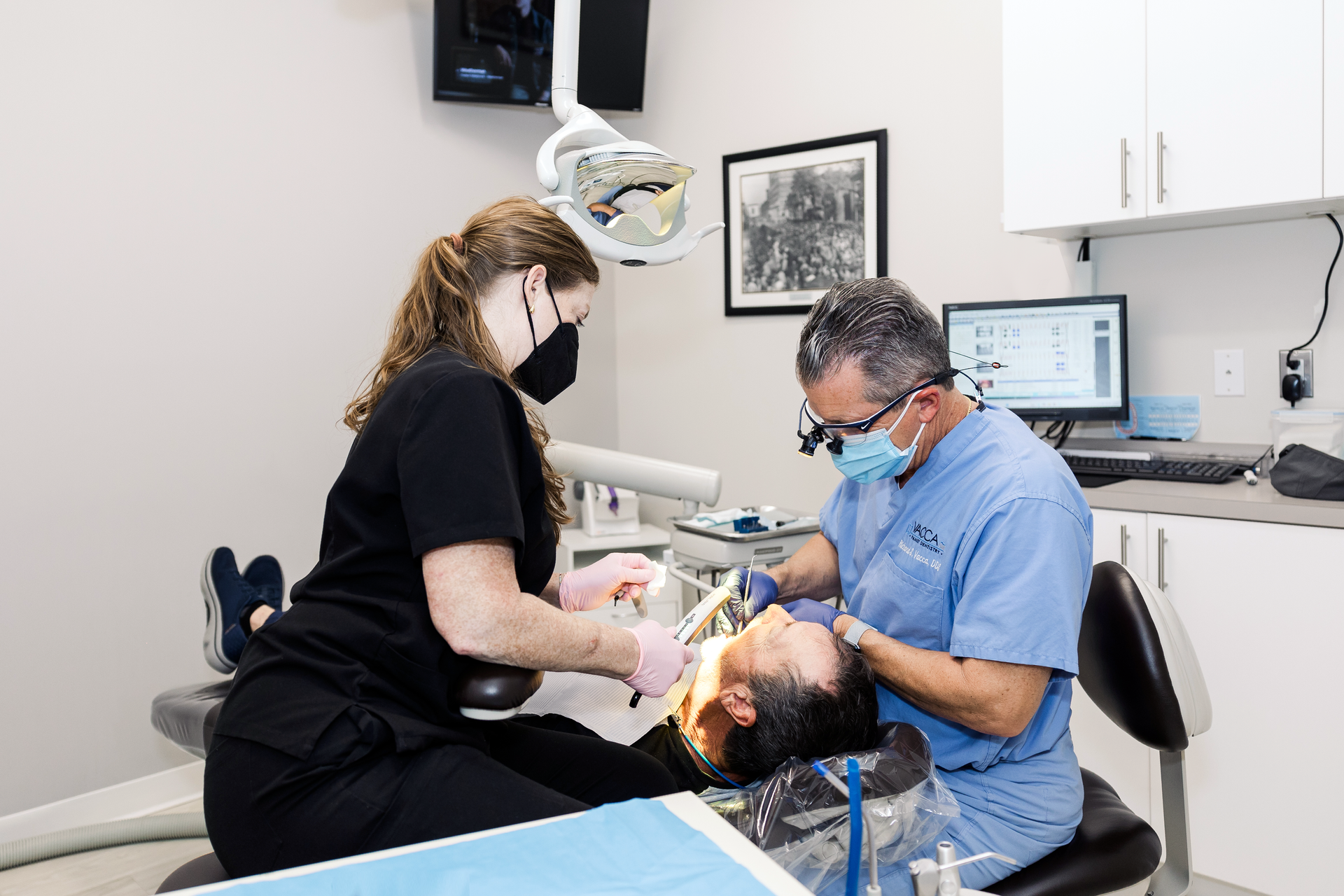 A dentist is examining a patient 's teeth in a dental office.