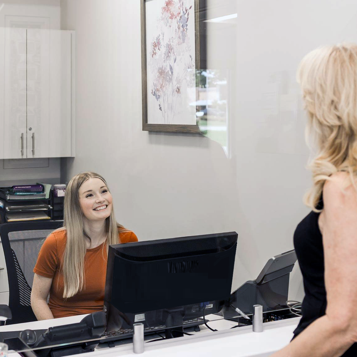 A dentist is talking to a patient in a dental chair.