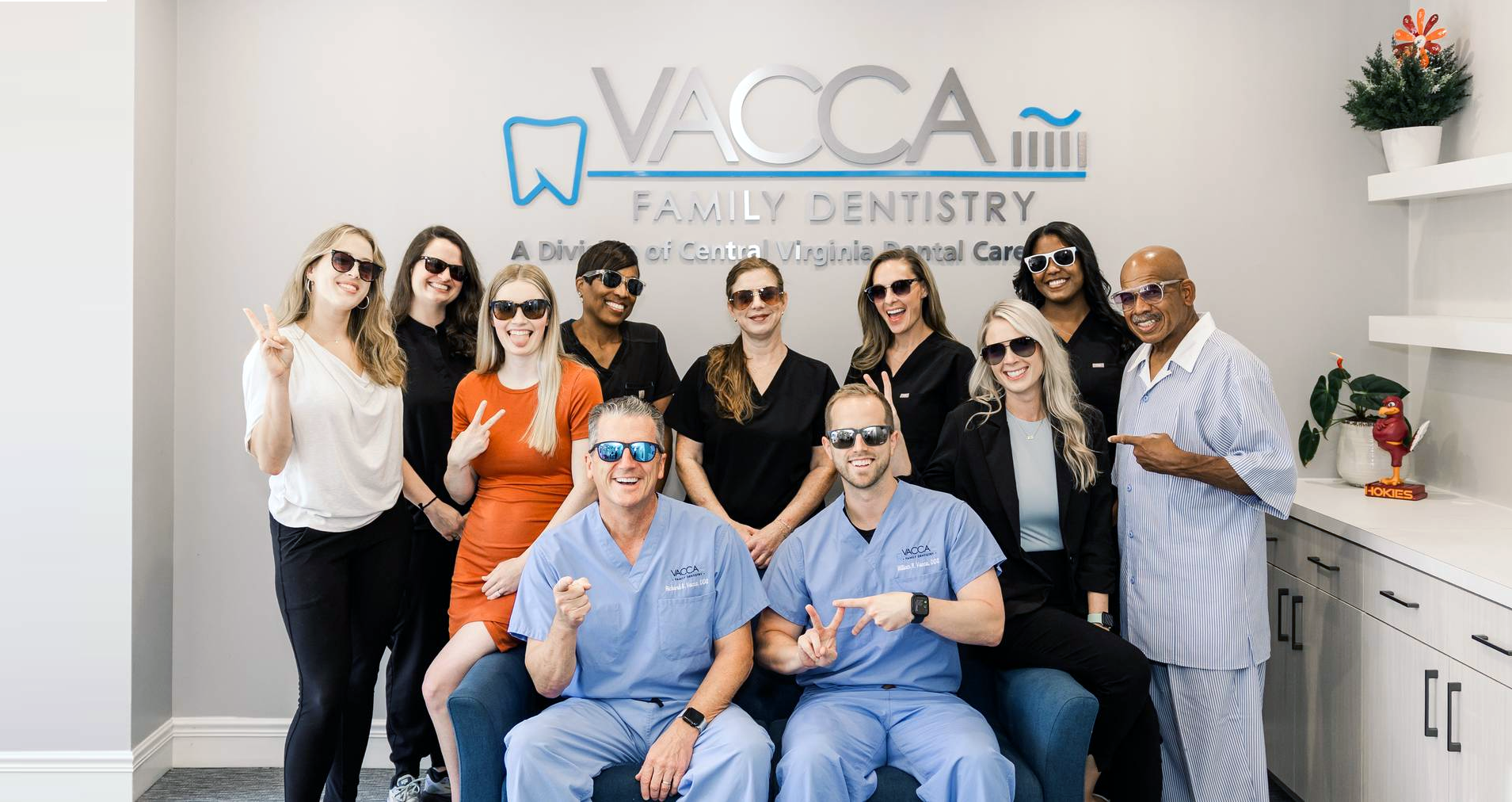 A group of people are posing for a picture in front of a dental office.