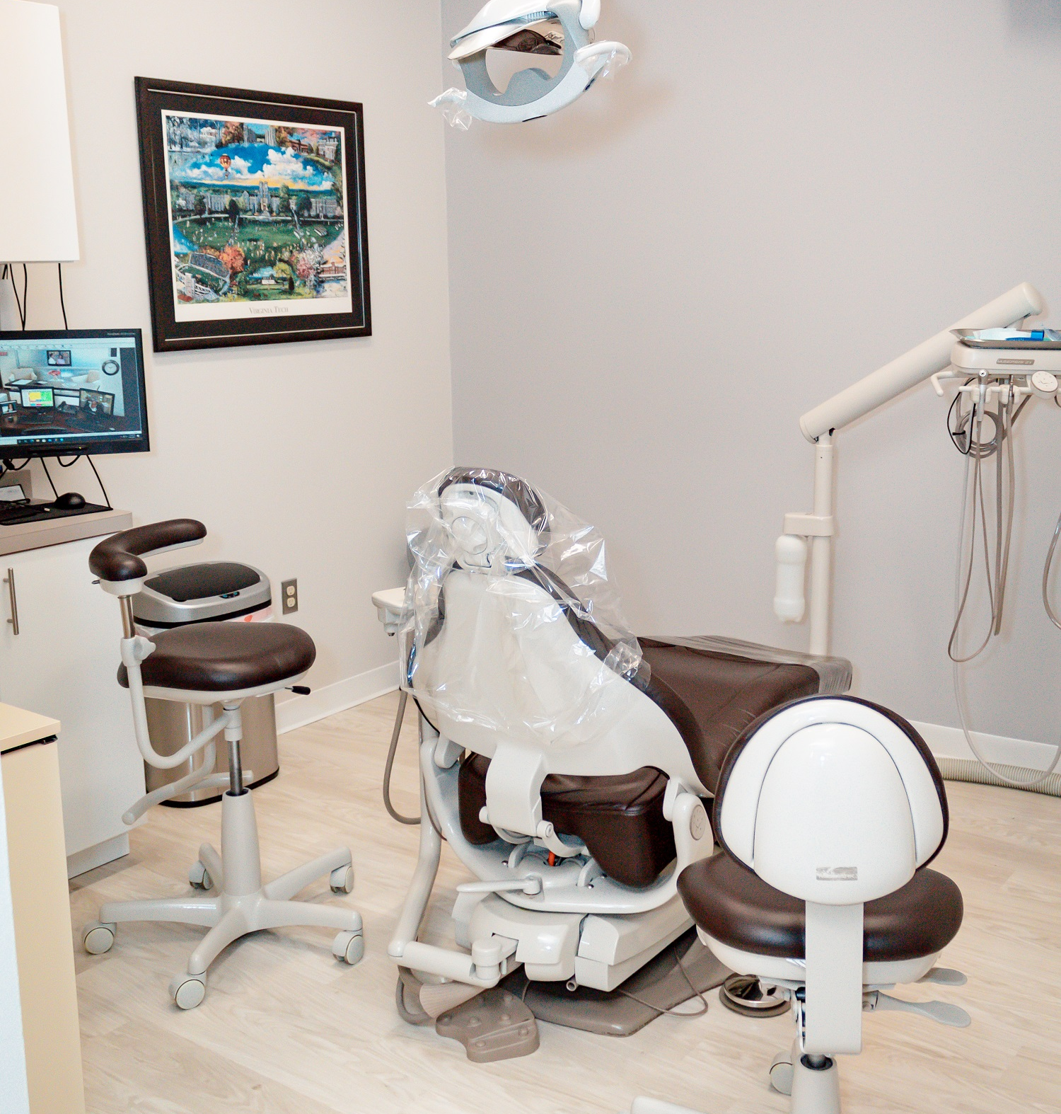 A dental office with a dental chair and a monitor