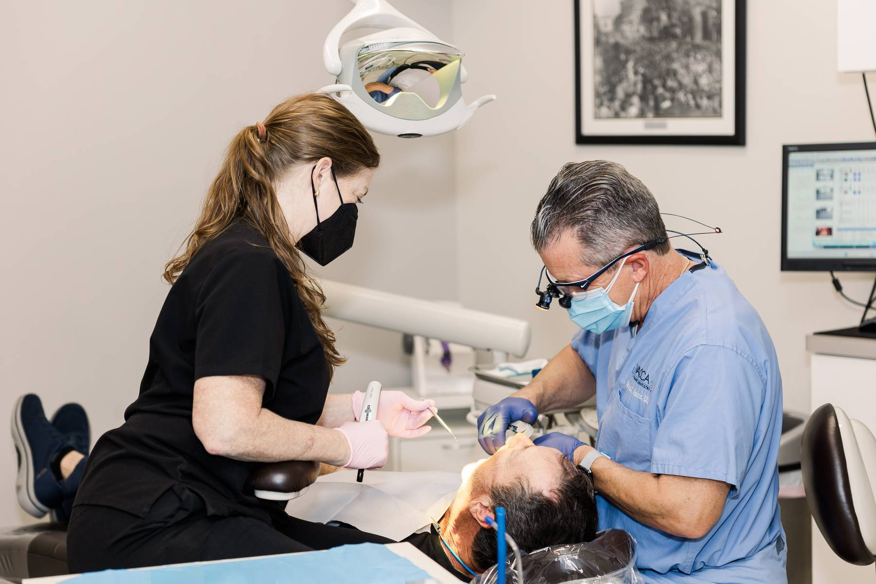 A dentist is examining a patient 's teeth in a dental office.