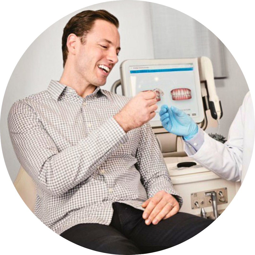 A man in a plaid shirt is sitting in a dental chair