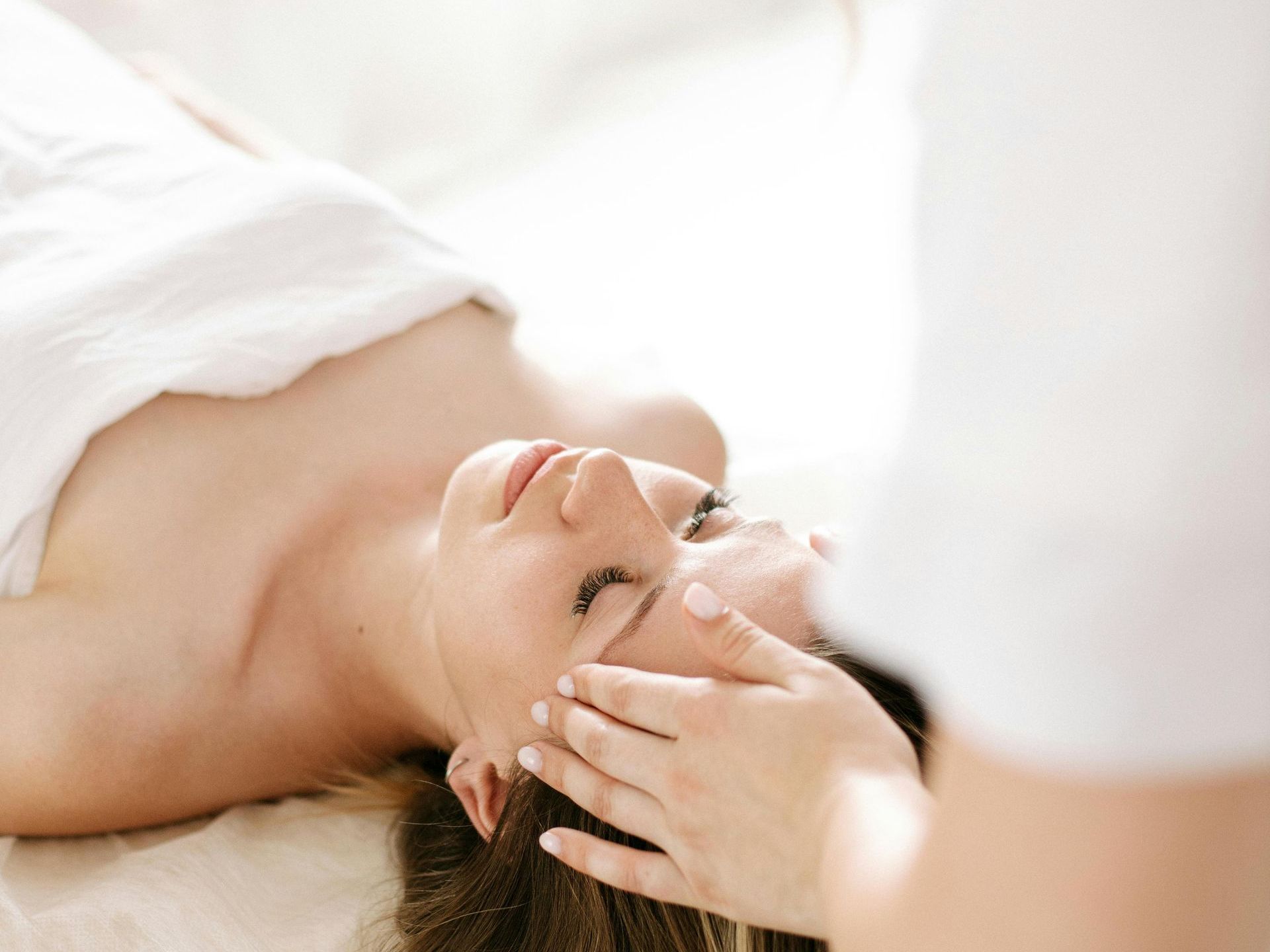 A woman is getting a head massage at a spa.