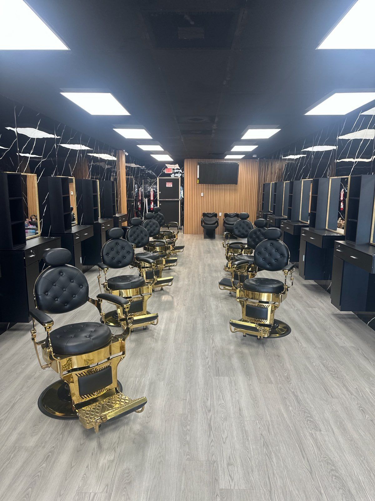 Barber trimming a client's hair with clippers in a salon