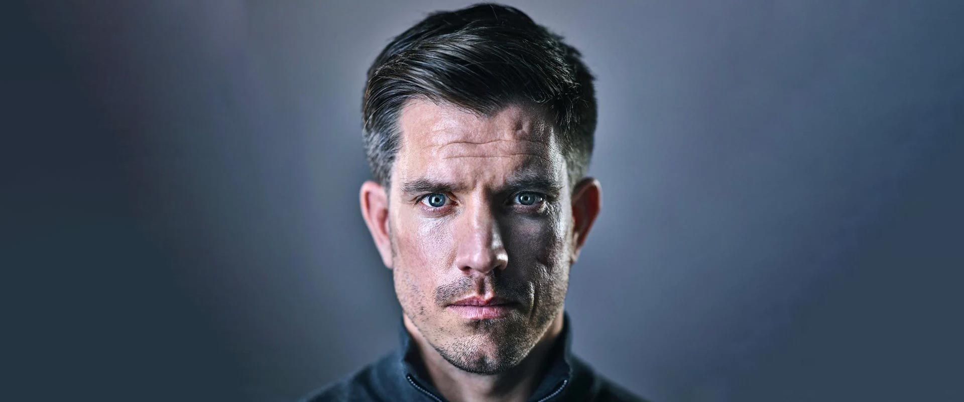 A close up of a man 's face with a blurred background.