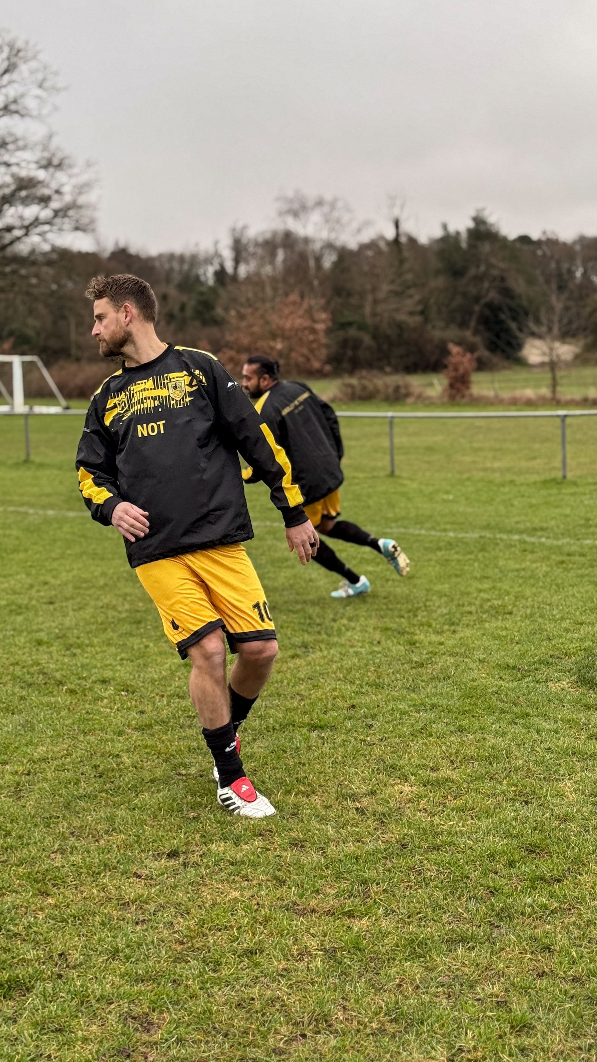 Two men are playing soccer on a field.