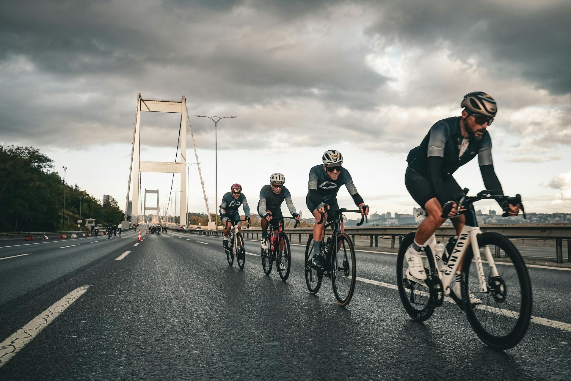 A group of people are riding bicycles on a bridge.