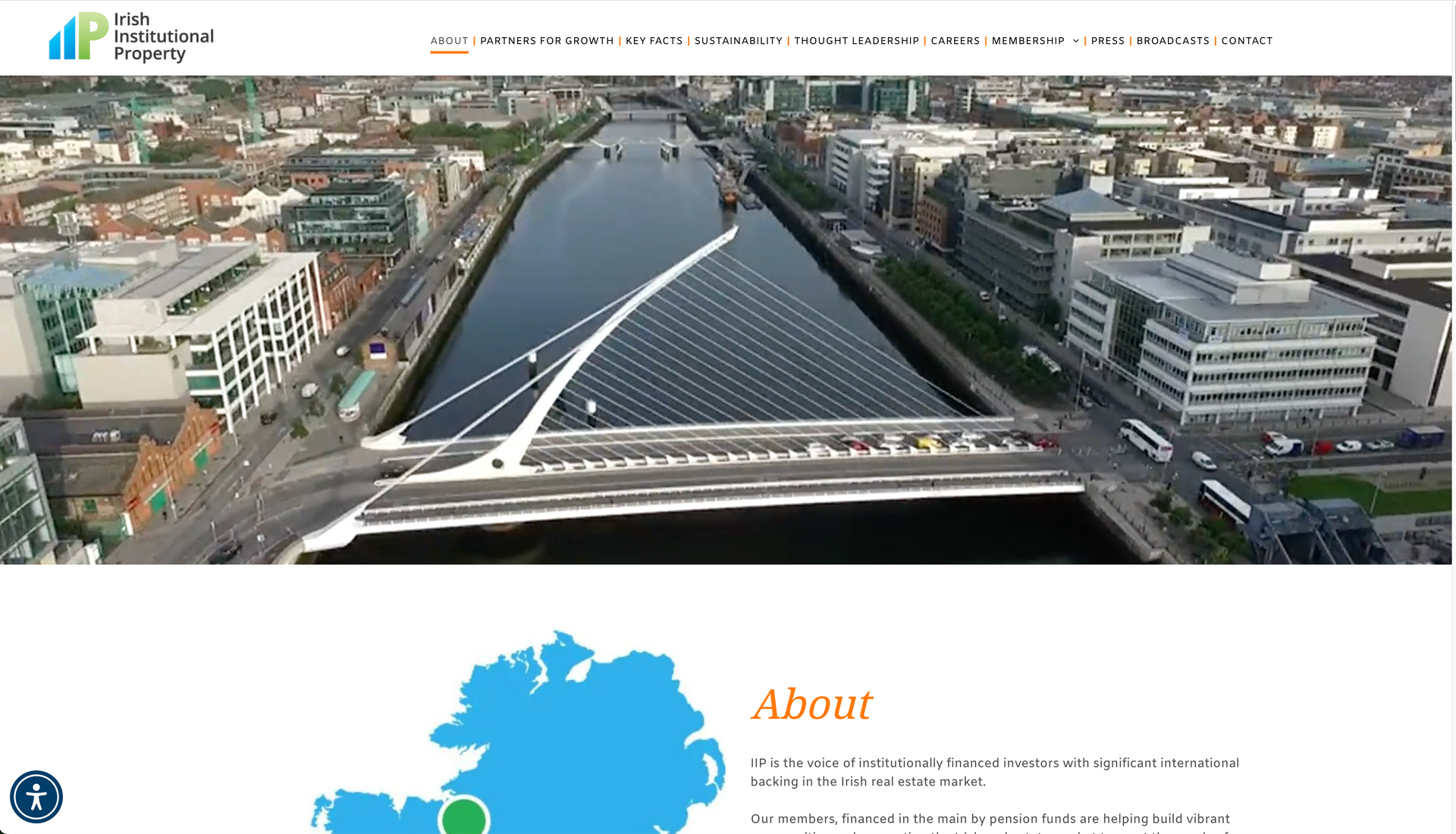 Aerial view of Dublin with a modern bridge over the river and a map of Ireland with a green dot.