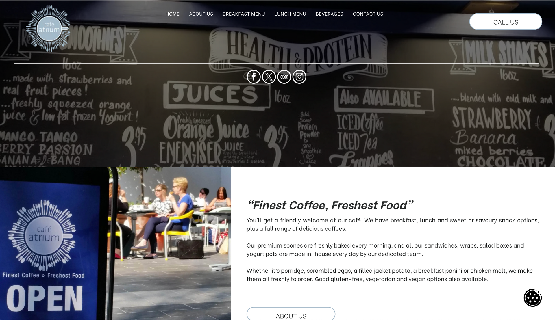 Menu board with health and protein drinks, coffee shop open sign, people sitting at tables.