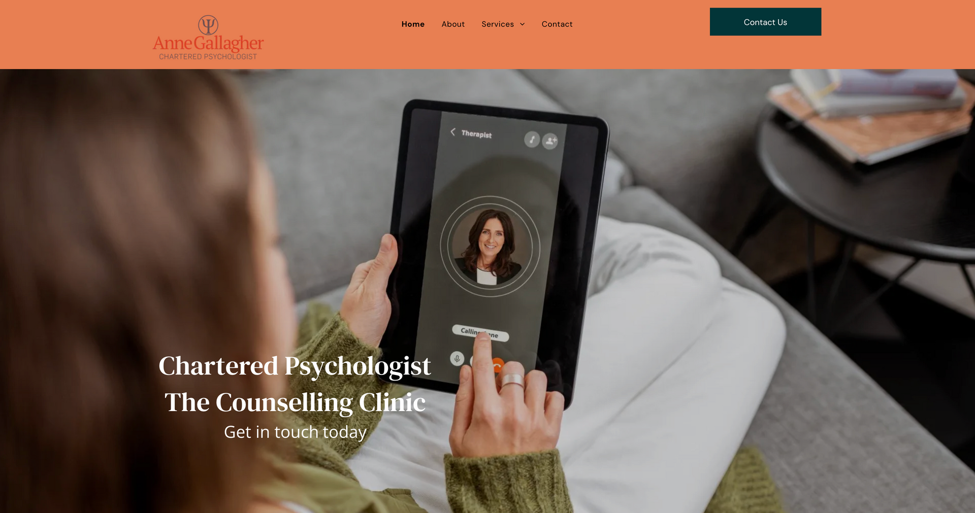 Woman using tablet for online counseling session; clinic logo and text visible.