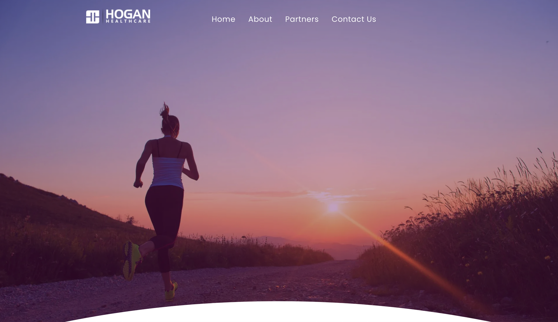 Woman running on a road at sunset.