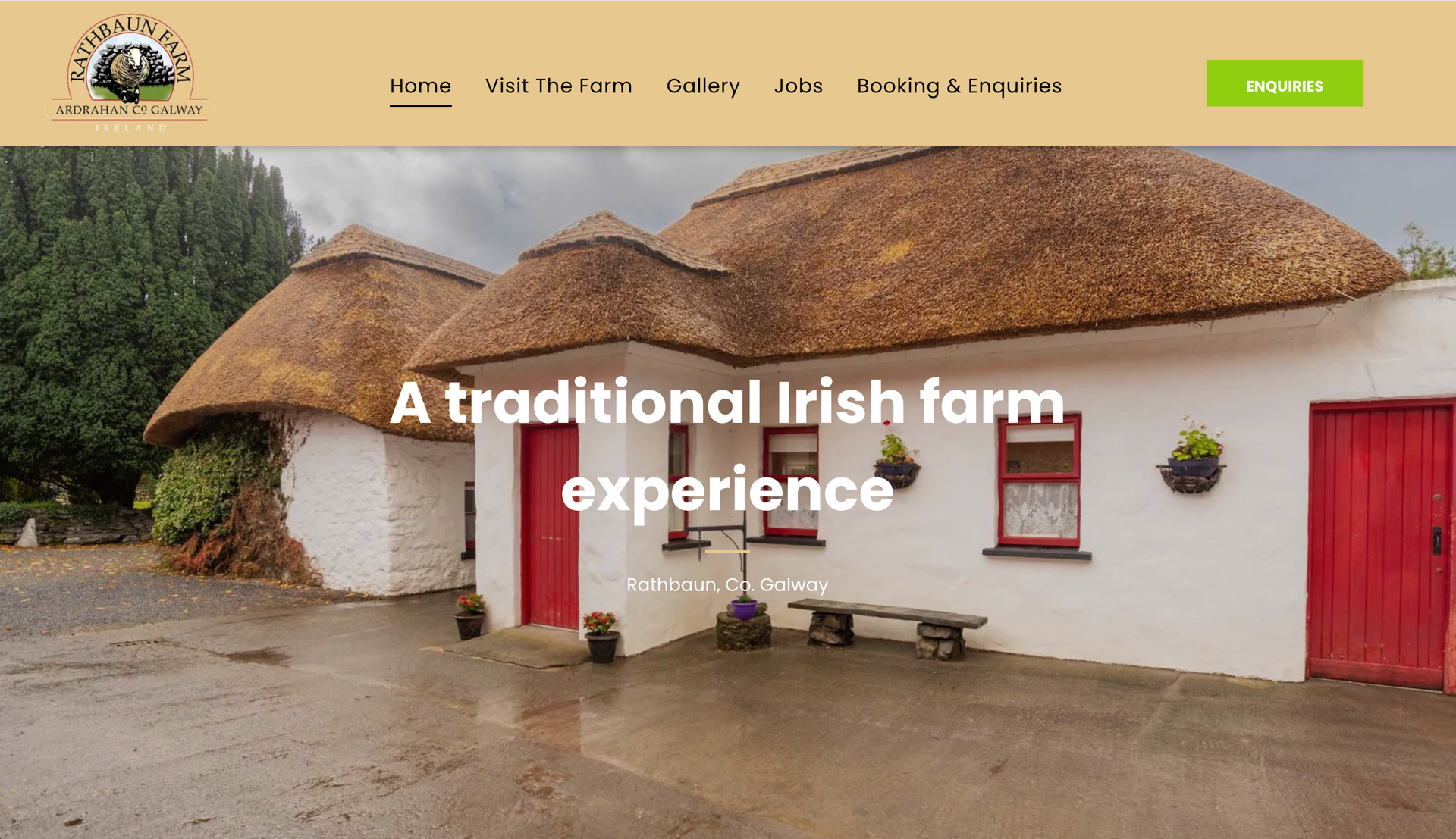 Thatched roof cottage with red doors, stone facade, and a bench. 