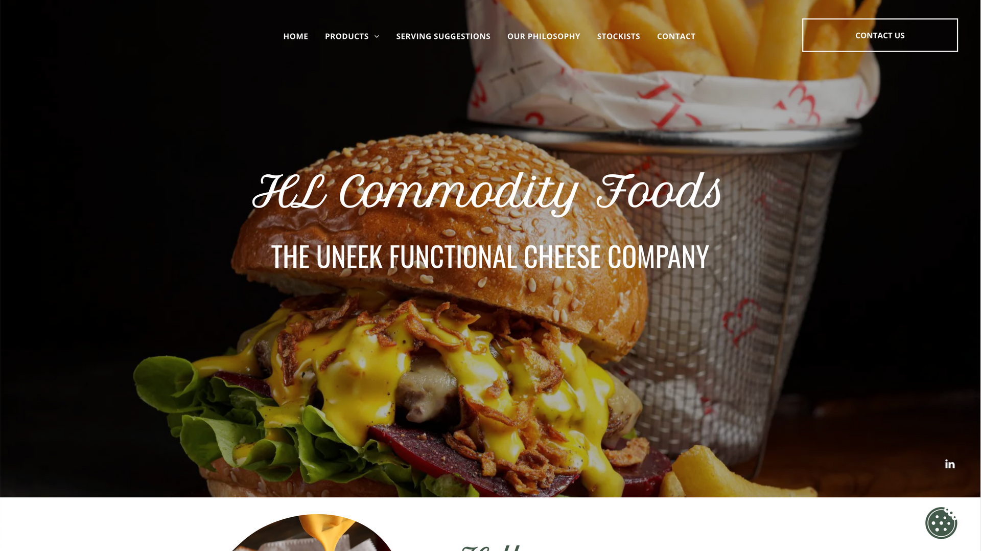 Burger with cheese, onions, and fries in front of a basket, and a black background. 