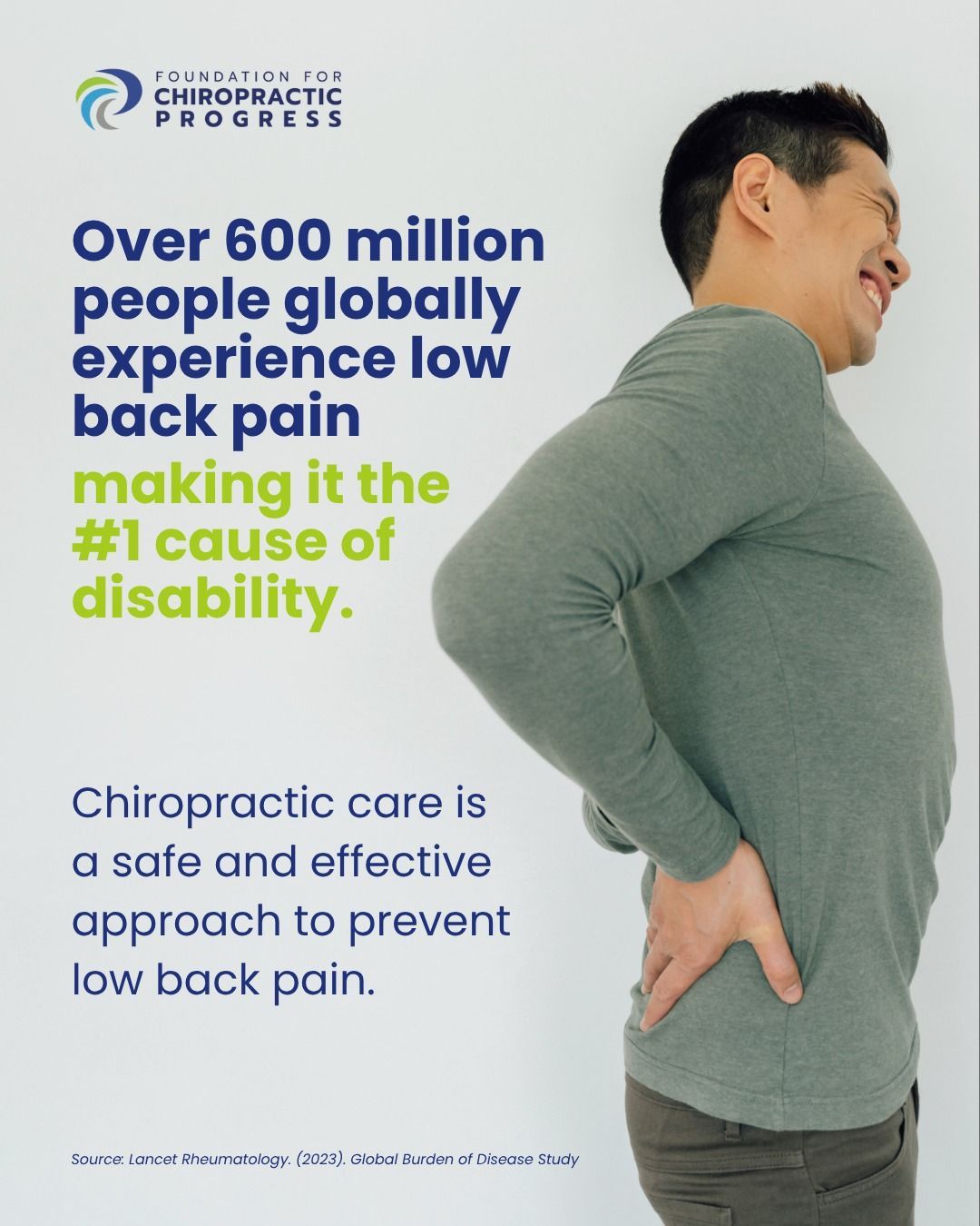 Man in gray shirt grimacing while holding his lower back in pain