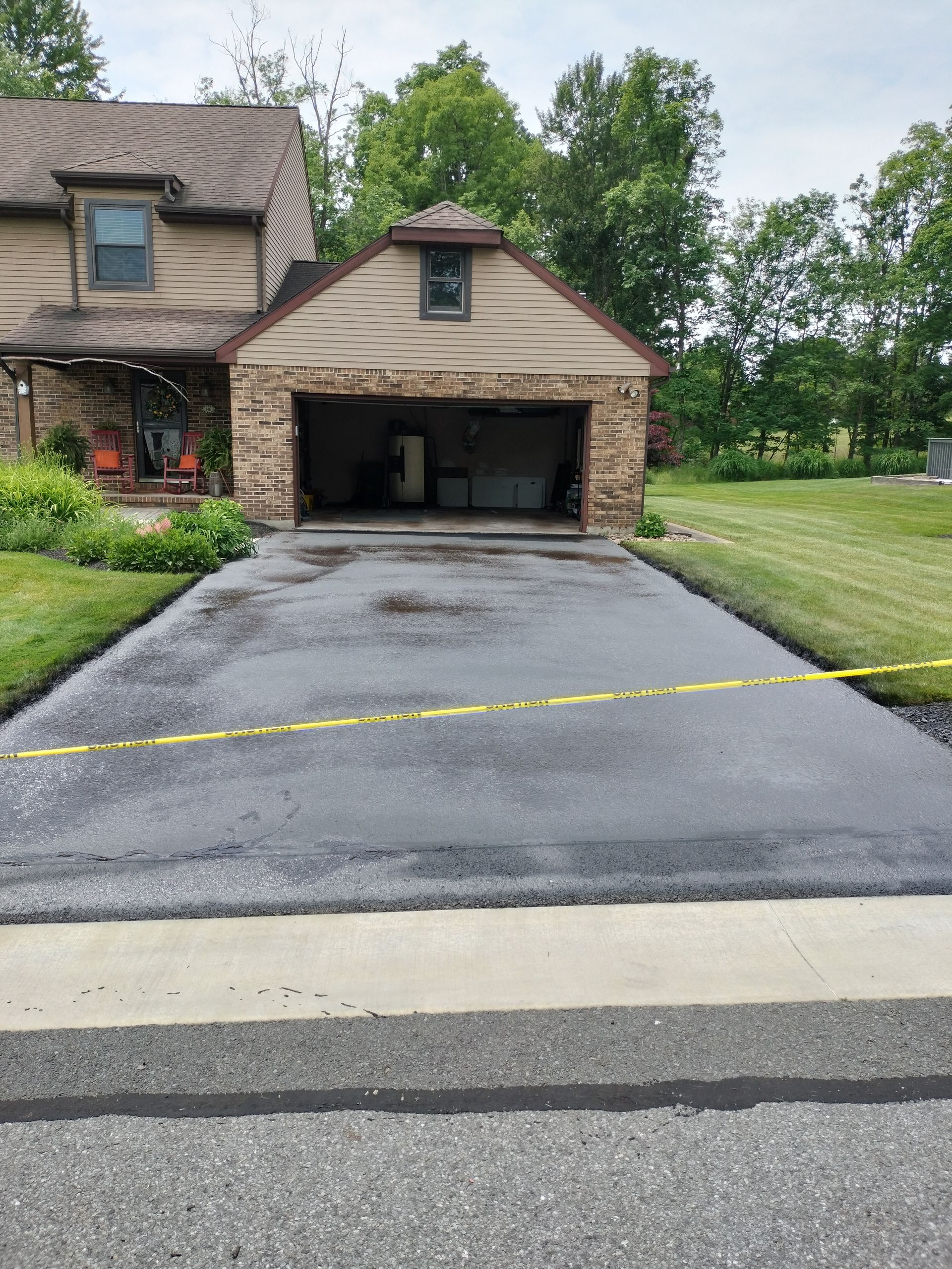 A driveway in front of a house with a garage.