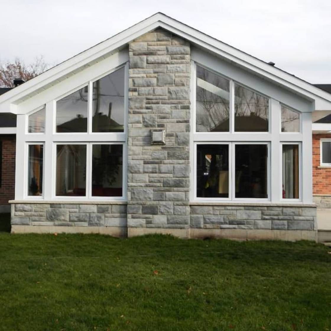Une maison avec une façade en pierre et des fenêtres blanches