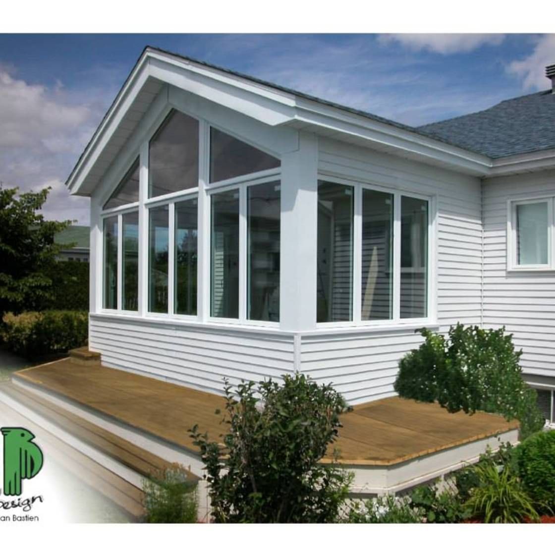 Une maison blanche avec un toit bleu et beaucoup de fenêtres