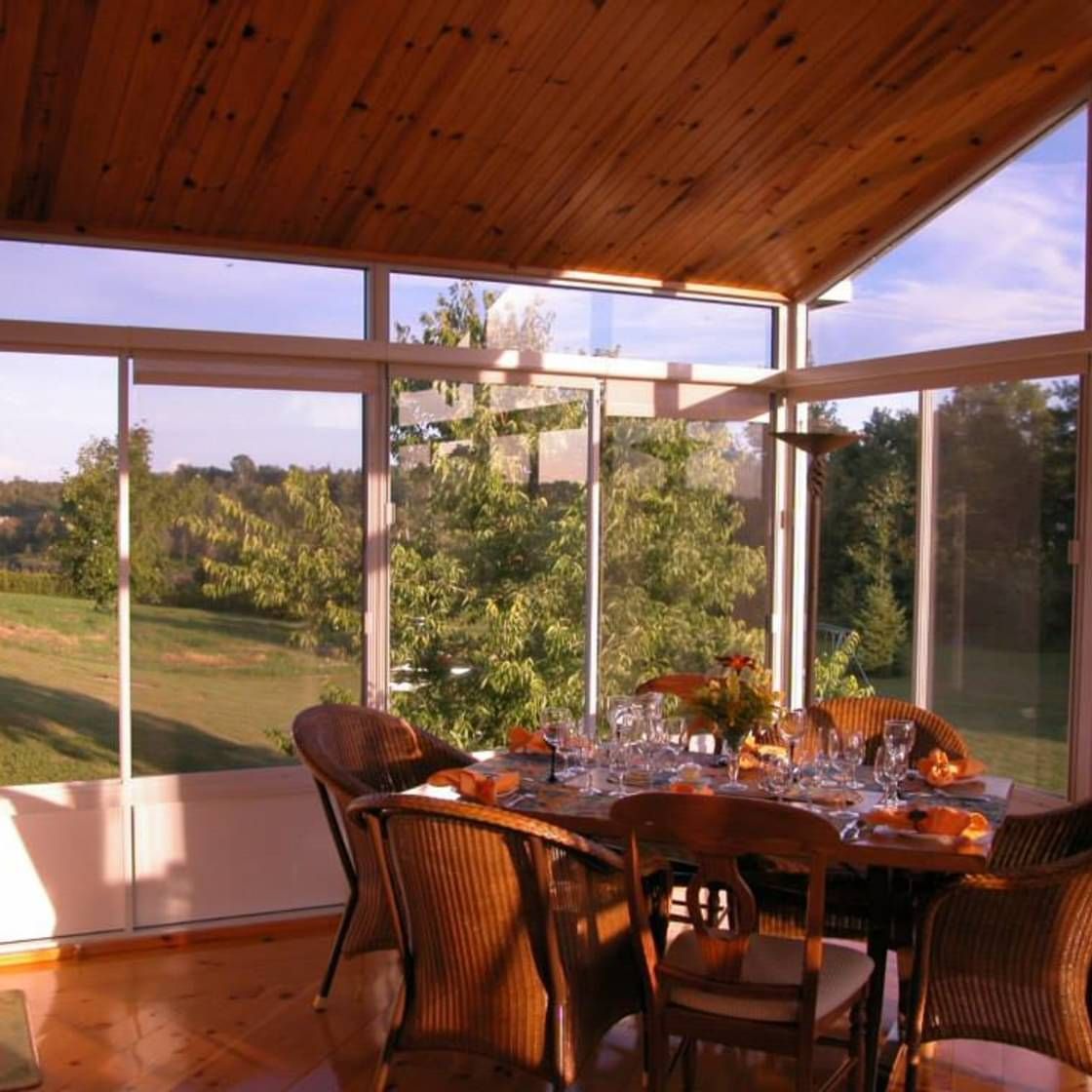 Une salle à manger avec une table et des chaises et une vue sur un champ