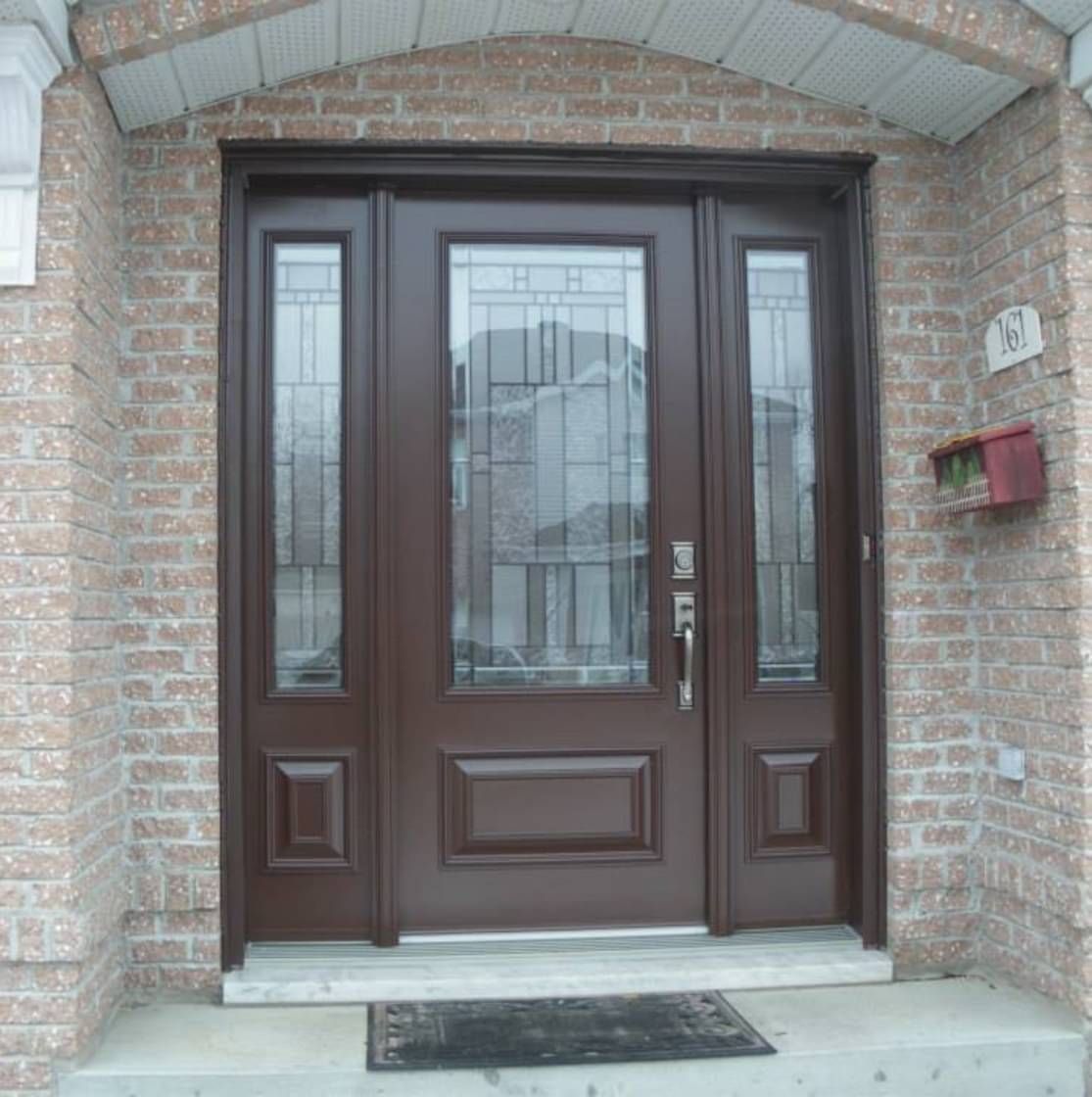 La porte d'entrée d'une maison en briques avec une porte marron