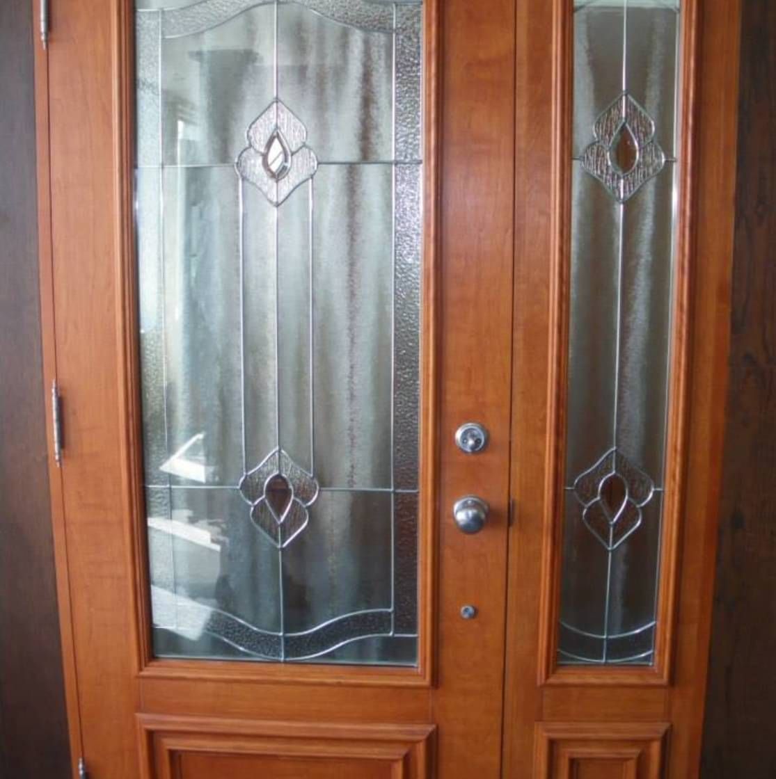 Une porte en bois avec un motif de vitrail dessus