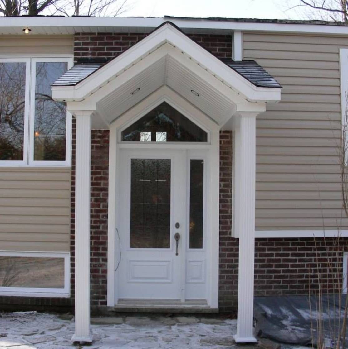 Une maison avec un porche et une porte blanche