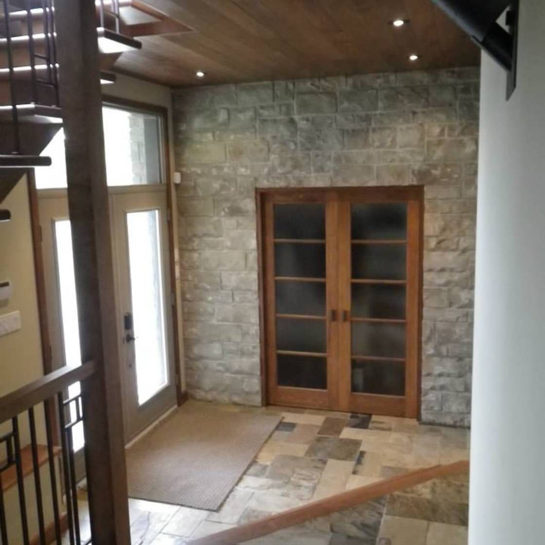 Un couloir avec des escaliers menant à une porte