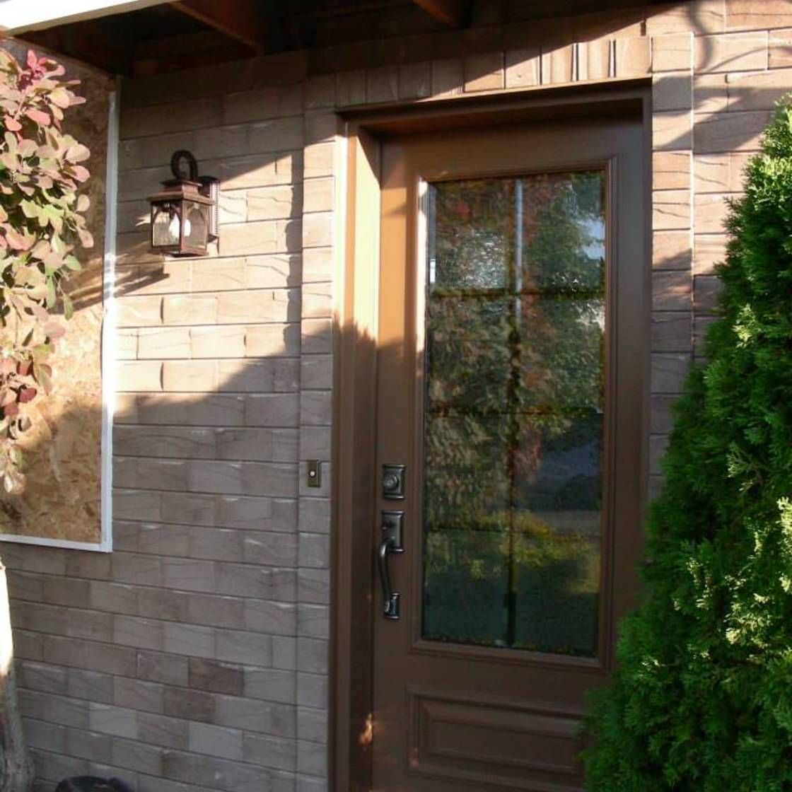Un bâtiment en briques avec une porte marron et une lanterne