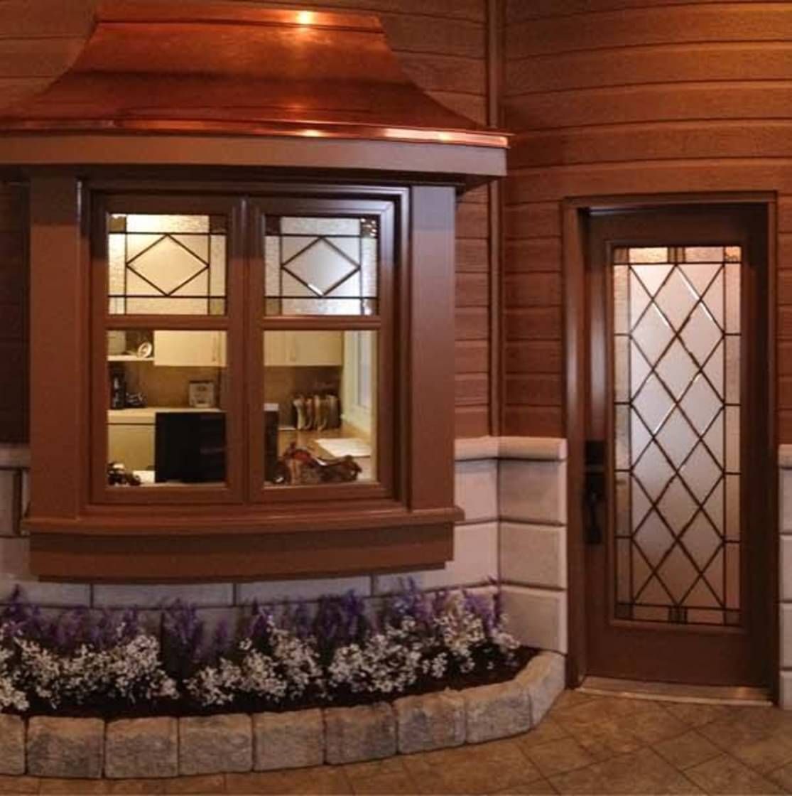 Une maison avec un toit en cuivre et une porte en vitrail