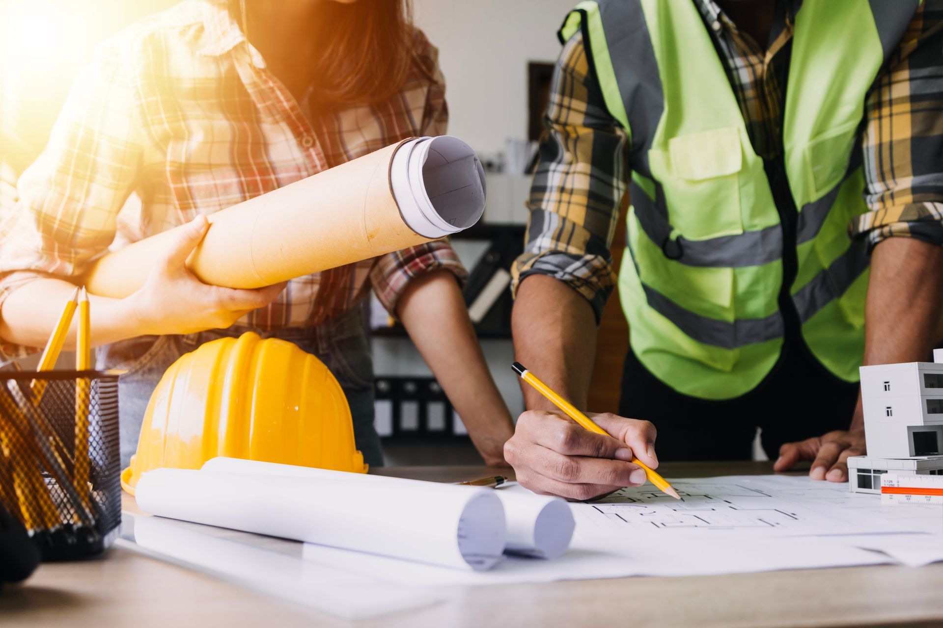 Un couple d'ouvriers du bâtiment sont assis à une table et regardent un plan.