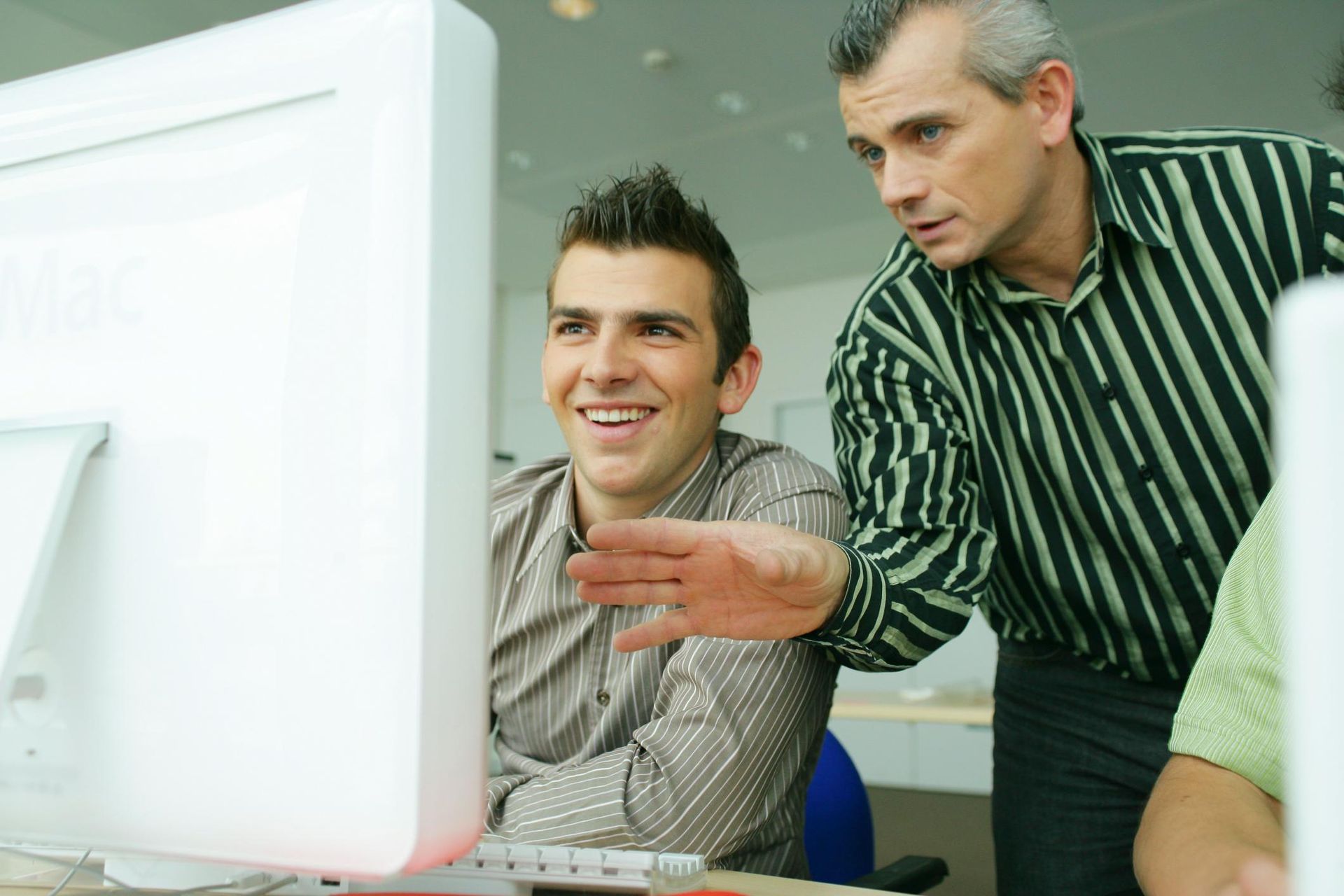 two men are looking at a computer screen