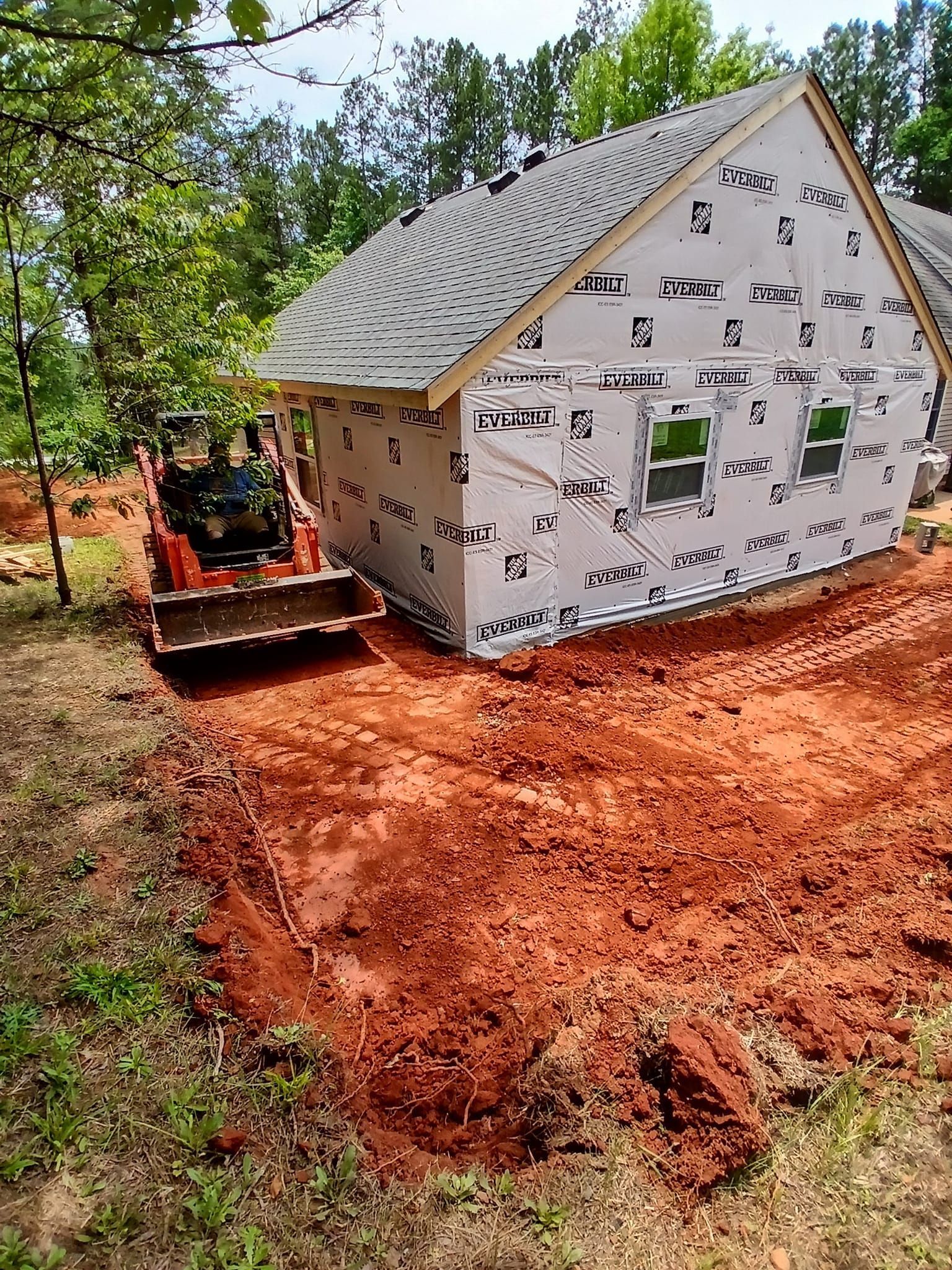 A house is being built in the middle of a dirt field.