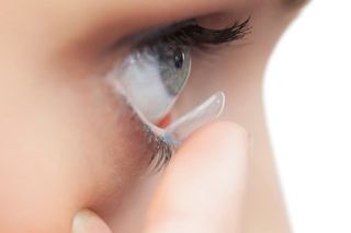 Extreme close up on young model applying contact lens - Eye Care Center in Holicong, PA