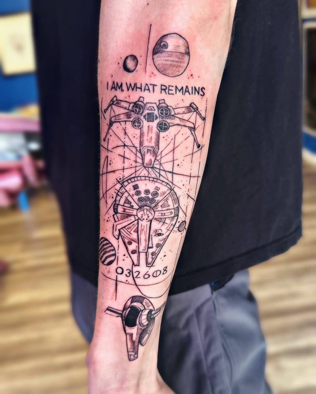 A black-ink Star Wars tattoo on a forearm featuring an X-wing, Millennium Falcon, Death Star, and text: 