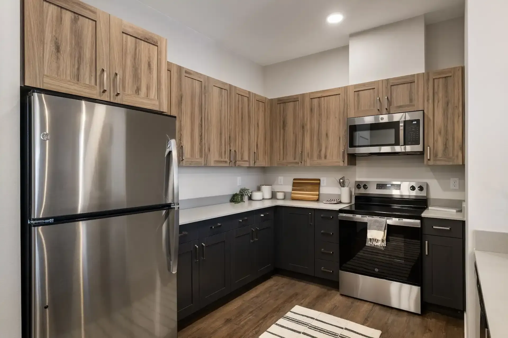 Kitchen with wood cabinets, stainless steel appliances, and dark gray lower cabinets.