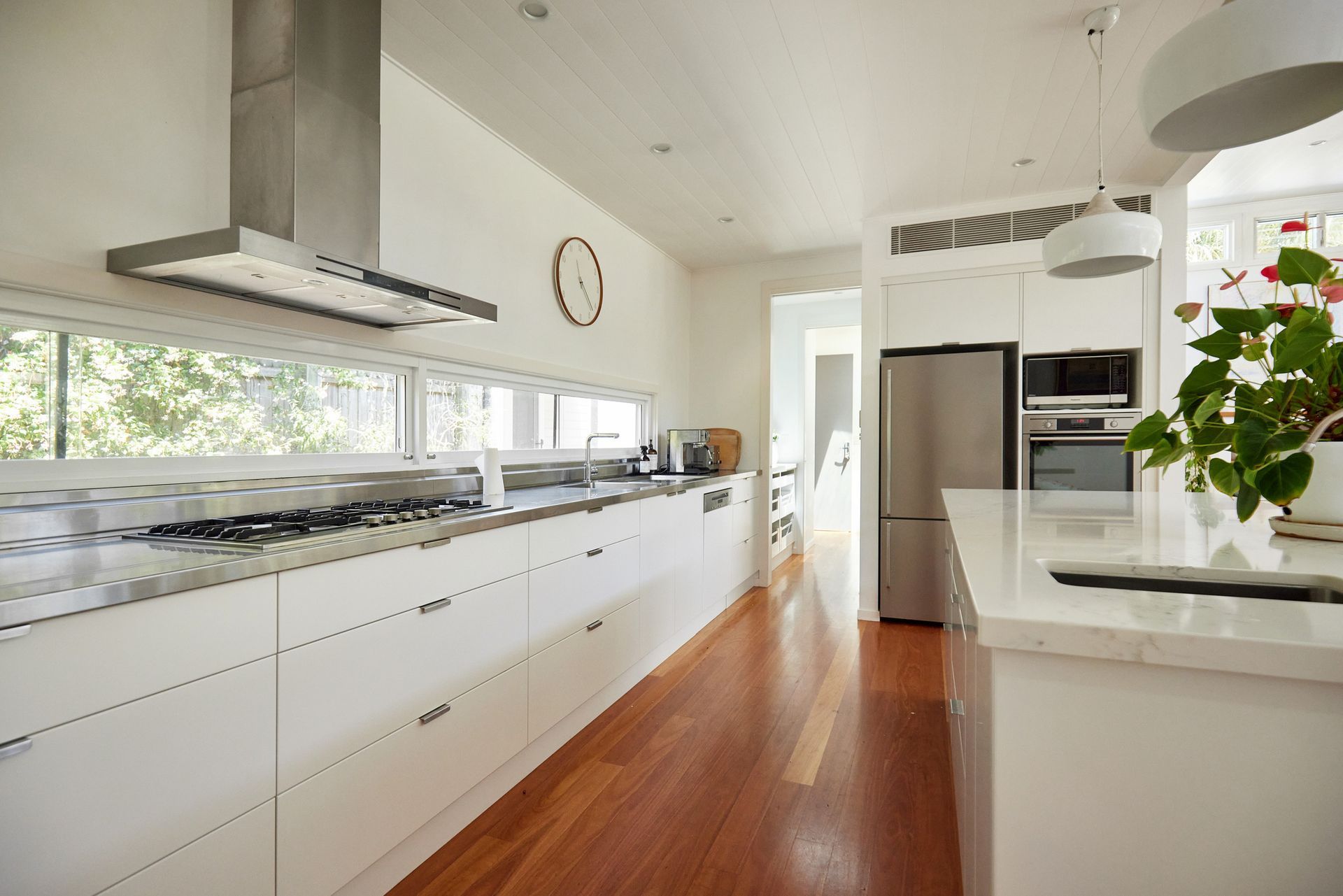 A kitchen with white cabinets , stainless steel appliances , a refrigerator and a stove.