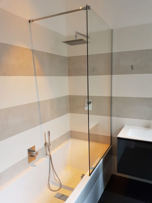 vasca da bagno con pannello in vetro