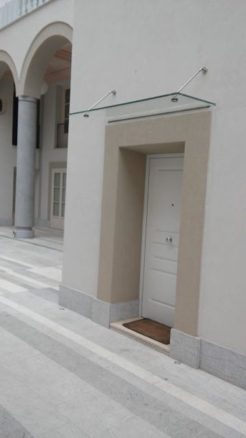 porta di un palazzo con pensilina in vetro