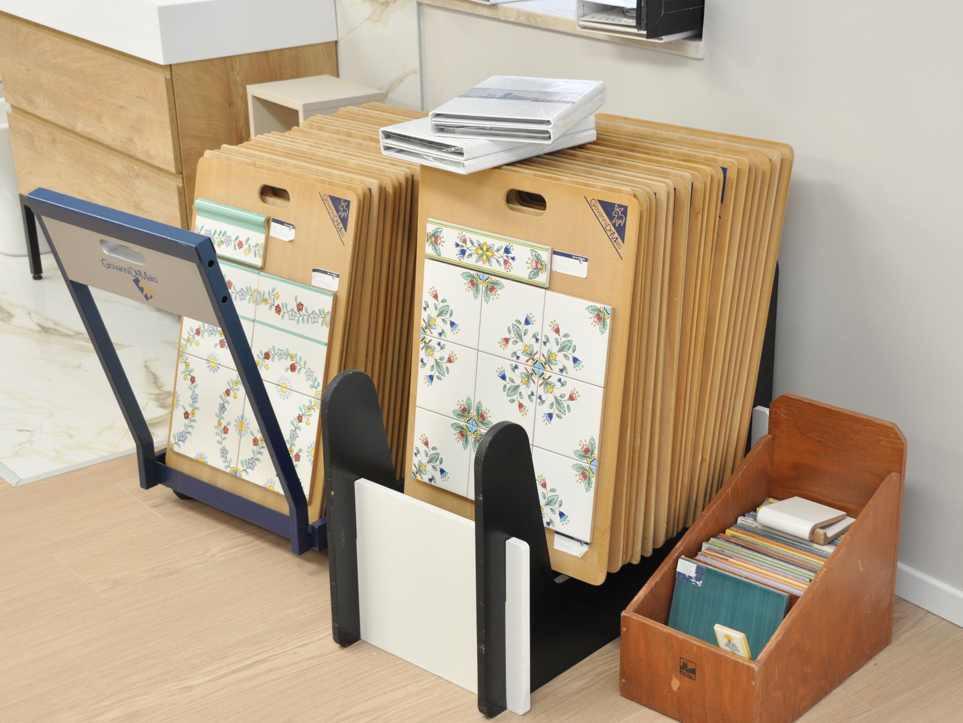 Una serie di piastrelle è posta su un pavimento in legno accanto a una scatola di legno.