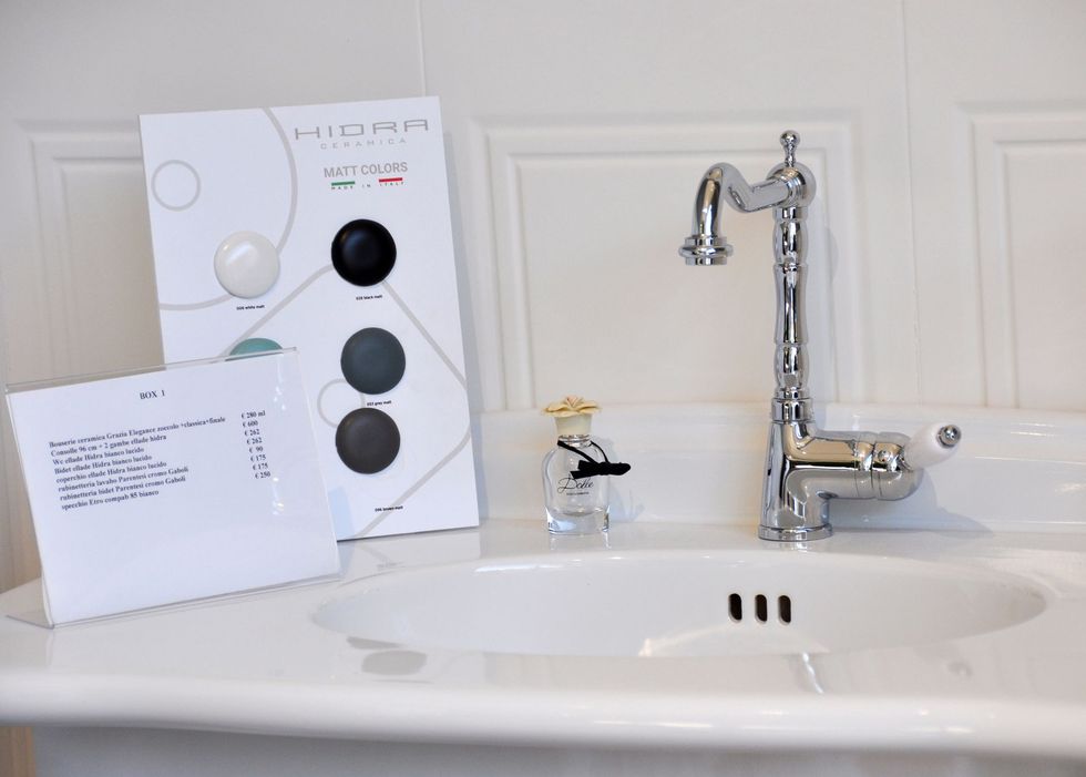 Un lavandino del bagno con un rubinetto e una rivista sul bancone.