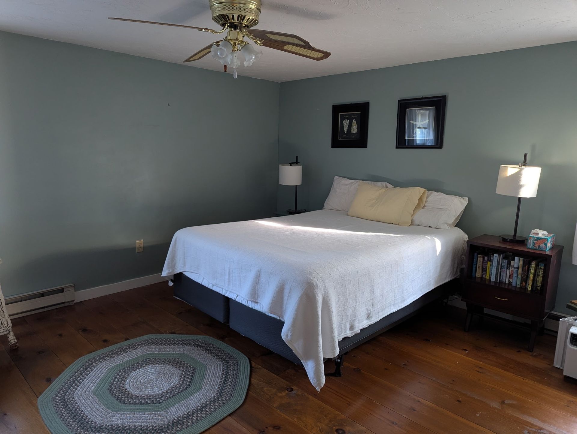 A bedroom with a large bed and a ceiling fan