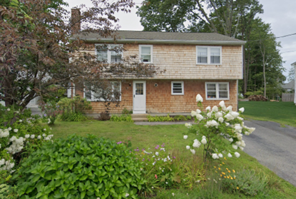 A large house with a lot of flowers in front of it.