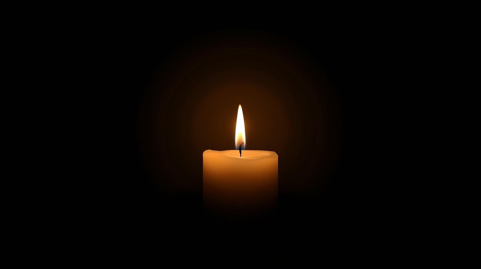 Lit candle in a dark room. Warm orange flame.